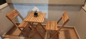 duas cadeiras de madeira e uma mesa com um vaso de flores em New luxury and quiet apartmant em Istambul
