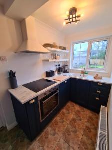 a kitchen with black cabinets and a stove top oven at Stylish 3 Bedroom Galway House in Galway