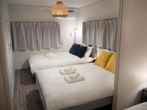 Dos camas en una habitación pequeña con toallas. en Lido East Shinagawa　, en Tokio