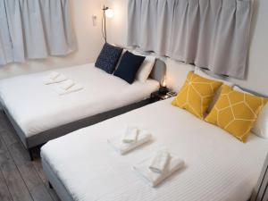 Dos camas en una habitación con toallas blancas. en Lido East Shinagawa　, en Tokio