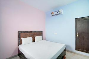 a bedroom with a white bed and a door at OYO SM GALAXY in Kānpur