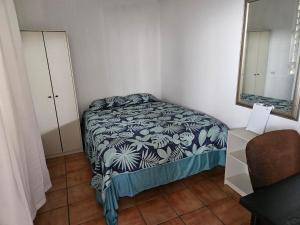 Dormitorio pequeño con cama y espejo en Newly remodeled Economical 5BR, Third floor, en Mayagüez