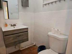 y baño con aseo blanco y lavamanos. en Newly remodeled Economical 5BR, Third floor, en Mayagüez