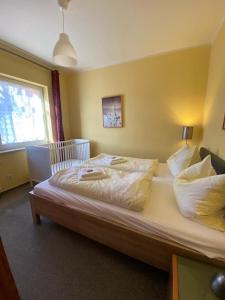 een slaapkamer met een groot bed met witte lakens en kussens bij Apartments in der Kopenhagener Straße in Rostock