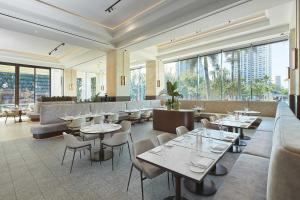 un restaurante con mesas, sillas y ventanas grandes en Marriott Vacation Club at Surfers Paradise, en Gold Coast