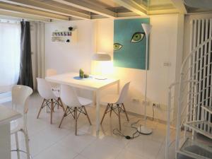 a dining room with a white table and chairs at Appartamento open space in Turin