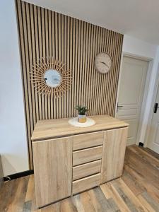 Zimmer mit einer Holztheke mit zwei Uhren an der Wand in der Unterkunft appartement cosy à seloncourt in Seloncourt