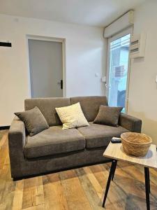 ein Wohnzimmer mit einem Sofa und einem Tisch in der Unterkunft appartement cosy à seloncourt in Seloncourt