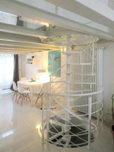 a room with a table and a spiral staircase at Appartamento open space in Turin