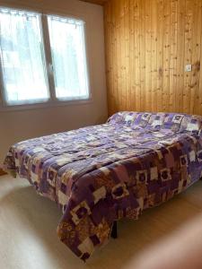 a bed in a bedroom with a quilt on it at Appartement Daniel in Lamoura