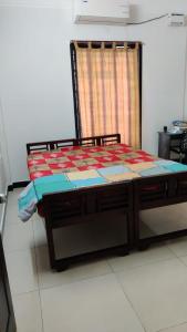 a bed sitting in a room with a window at Chez Bussy in Puducherry