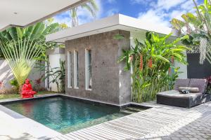 a swimming pool in front of a house at Villa Turtle in Seminyak