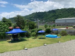 un patio trasero con sombrillas azules y una piscina en Lone Star Inn en san juan la union