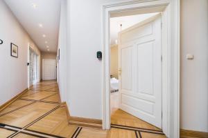 een hal met een witte deur en houten vloeren bij Apartamenty w Pałacu Pod Baranami in Krakau