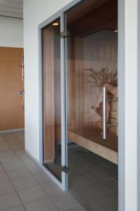 Una puerta de cristal en un baño con una mesa. en Helnan Marselis Hotel, en Aarhus