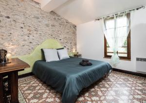 卡尔卡松L'atypique, La Vue et le Standing du 36 ! Emplacement, clim et extérieur !的一间带床的卧室，位于一间有石墙的房间里