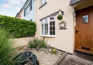 a house with a door and flowers in front of it at Coastguard Cottage in Paignton