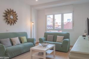 希洪的住宿－AV Gijón Palencia 3，客厅配有两张绿色沙发和一张桌子