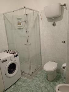 a shower stall with a washing machine in a bathroom at Nomentum House in Mentana