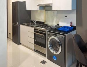 a kitchen with a stove and a washing machine at VIP Studio @ Damac Hills 2 in Dubai