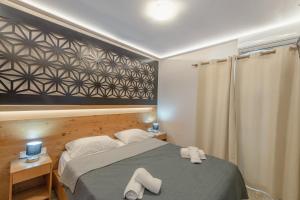 a bedroom with a bed with two white towels on it at Zama Suites in Zakynthos Town