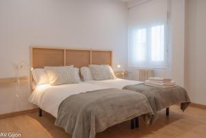 希洪的住宿－AV Gijón Palencia 3，卧室配有一张白色大床和床头板
