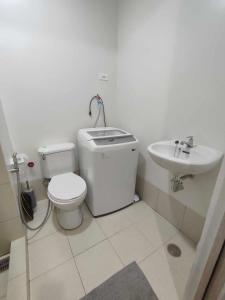 een badkamer met een toilet en een wastafel bij Trees Residence Condo in Manilla