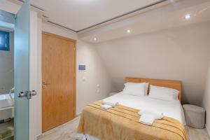 1 dormitorio con 1 cama con toallas en Zama Suites en Zakynthos