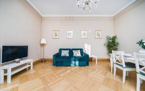 een woonkamer met een blauwe bank en een tafel bij Apartamenty w Pałacu Pod Baranami in Krakau