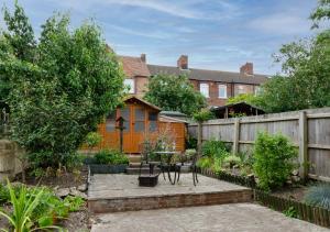 a garden with a wooden fence and a table at Beecroft Cottage in Cromer