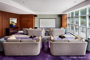 Habitación grande con sofás y pantalla de proyección. en Savills Residence Daxin Shenzhen Bay, en Shenzhen
