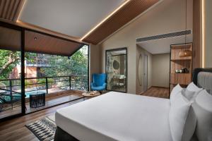 sypialnia z łóżkiem i balkonem w obiekcie Avataara Resort & Spa w mieście Anjuna