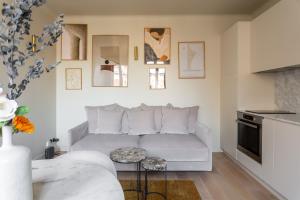 a living room with a white couch and a kitchen at The Carla Suite Eiffel Tower View in Paris