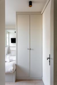 a bedroom with white closet doors in front of a bed at The Carla Suite Eiffel Tower View in Paris