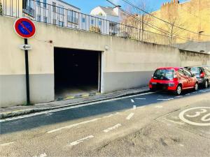 Le Châteaulin 2pers Parking في نانت: سيارة حمراء متوقفة أمام نفق