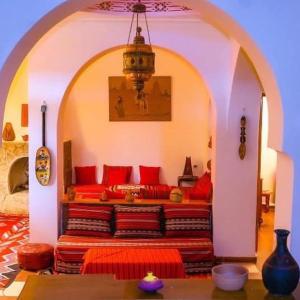 a room with a bed with red pillows at DAR EL WAFI in Timimoun