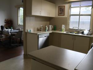 une cuisine avec un évier et un lave-vaisselle dans l'établissement 11 Barrett St, Bungalow QLD 4870, Australia, à East Trinity