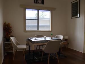 une table et des chaises dans une pièce avec une fenêtre dans l'établissement 11 Barrett St, Bungalow QLD 4870, Australia, à East Trinity