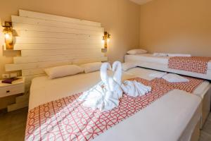 two beds with towels on them in a room at Agali Hotel in Limenaria