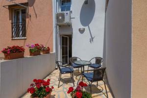a patio with chairs and a table and flowers at Holiday home in Crikvenica 39225 in Crikvenica