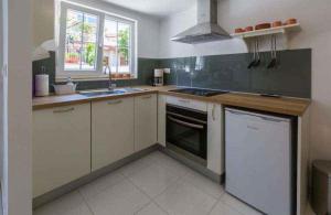 a kitchen with white cabinets and a stove top oven at Holiday home in Crikvenica 39225 in Crikvenica +9 photos