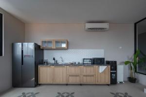 a kitchen with a stainless steel refrigerator and wooden cabinets at Cove Urbanier in Jakarta