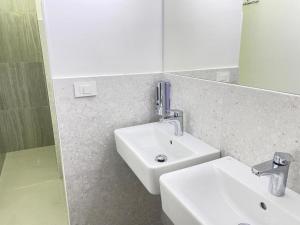 W łazience znajduje się biała umywalka i lustro. w obiekcie Rooms Miklošičeva w Lublanie