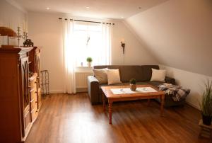 uma sala de estar com um sofá e uma mesa de centro em Ferienwohnung Adriane em Upgant-Schott