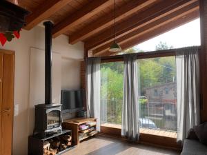 uma sala de estar com lareira e uma grande janela em La Cabanya de Mas Gingi em Sant Joan les Fonts