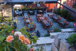 eine Außenterrasse mit Tischen, Stühlen und Blumen in der Unterkunft Hotel-Gasthof zur Sonne in Pappenheim