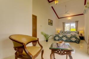 a living room with a chair and a bed at Ludo Private Pool Villa, WiFi-Caretaker-Parking, North Goa in Baga