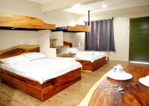 2 camas en una habitación con suelo de madera en Lone Star Inn en san juan la union