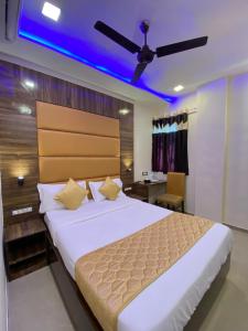 Hotel Blue Wellington - Near Mumbai Airport في مومباي: غرفة نوم بسرير كبير بسقف ازرق