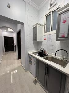 uma cozinha com um lavatório e uma bancada em بارك بلس للشقق المخدومة em AR Rummanah